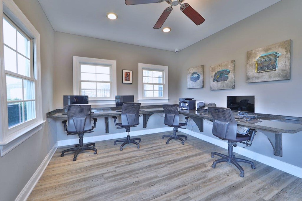a conference room with desks and chairs and a ceiling fan