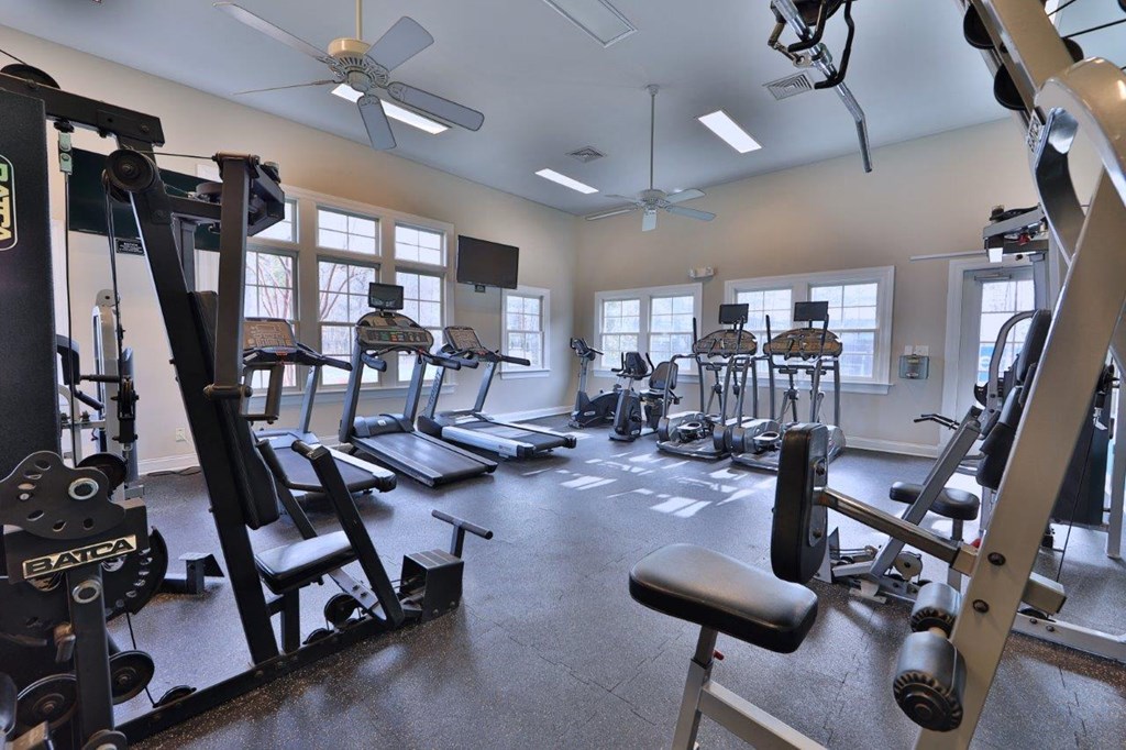 a gym with weights and other equipment in a building with windows