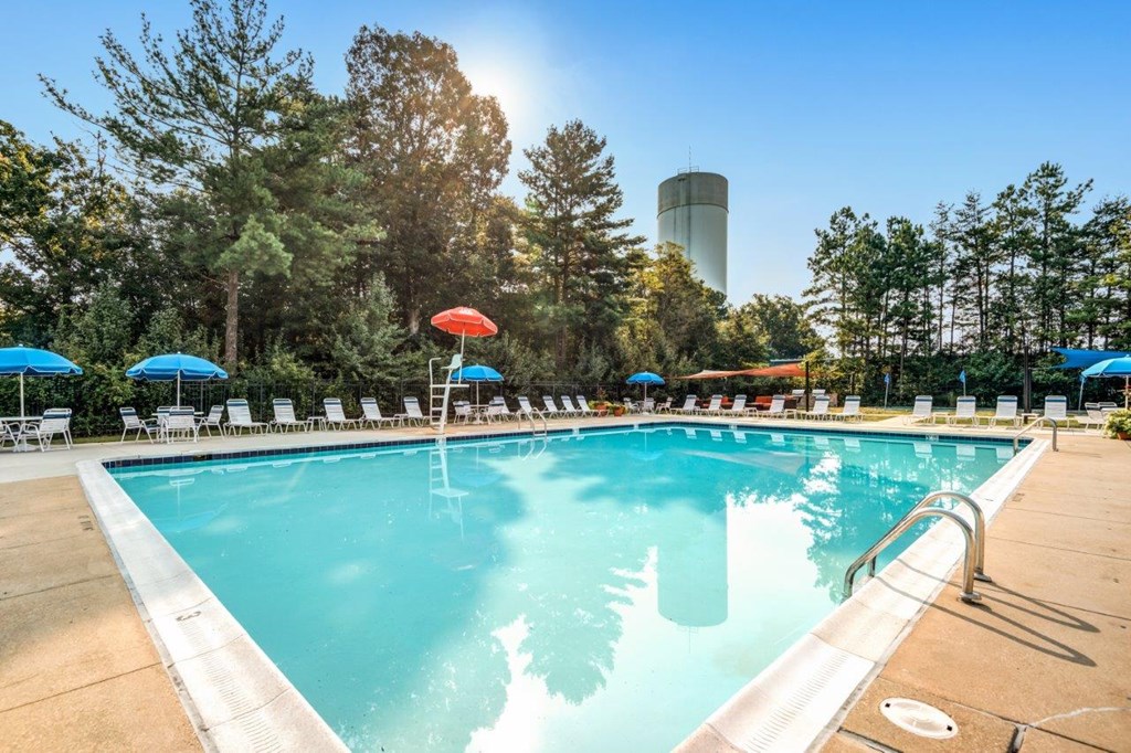 A large swimming pool with a waterfall feature and lounge chairs.