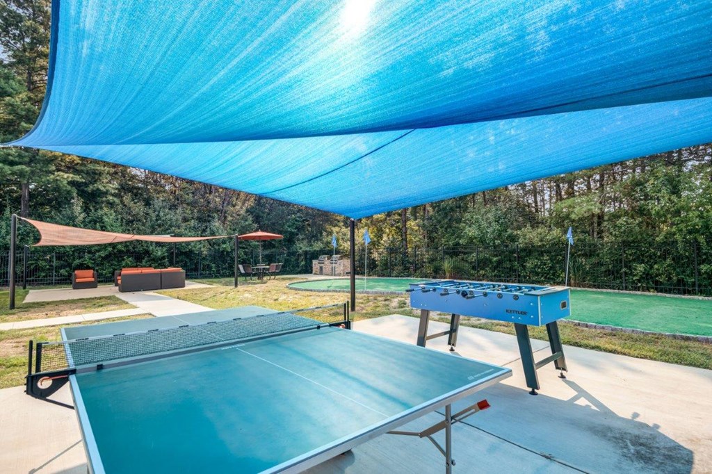 A blue shaded outdoor table tennis court.