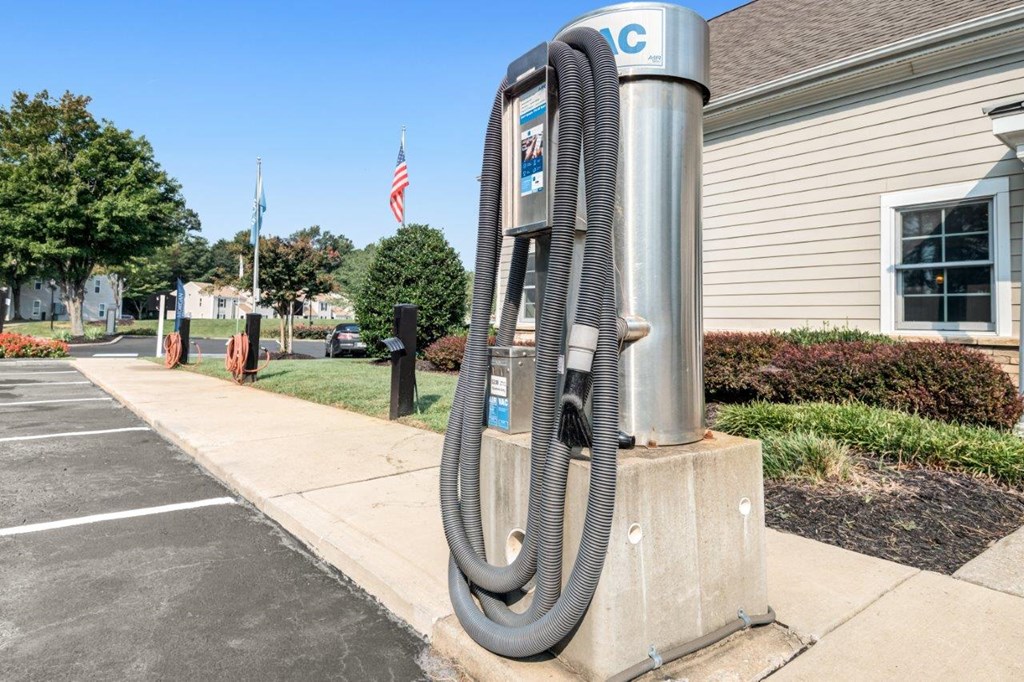 A parking lot with a parking meter and a building in the background.