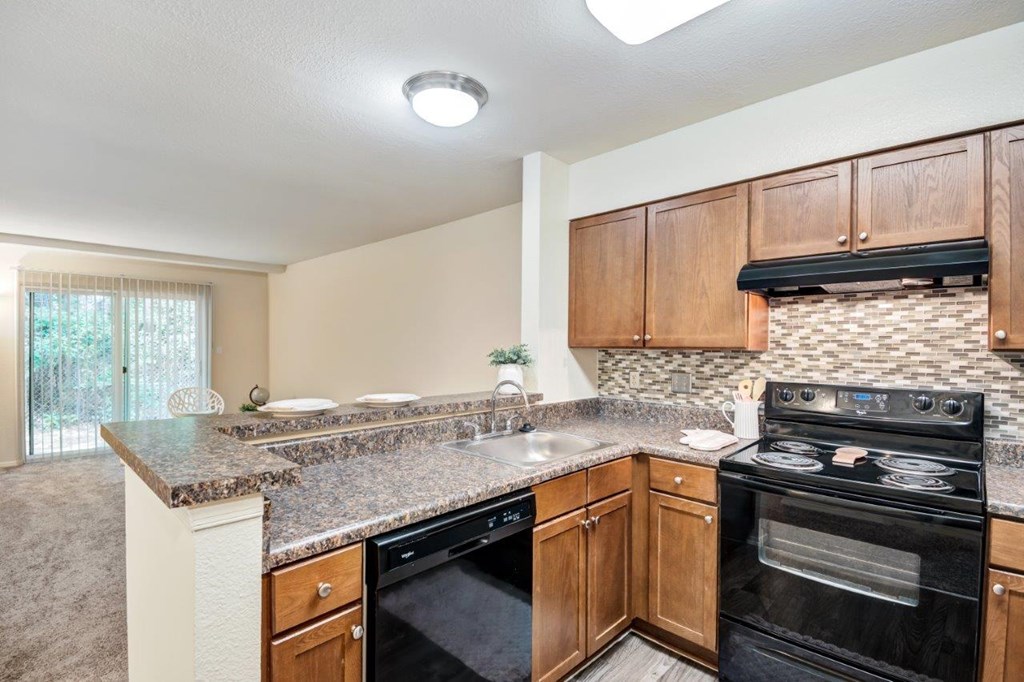 A kitchen with a black stove top oven and a counter top.