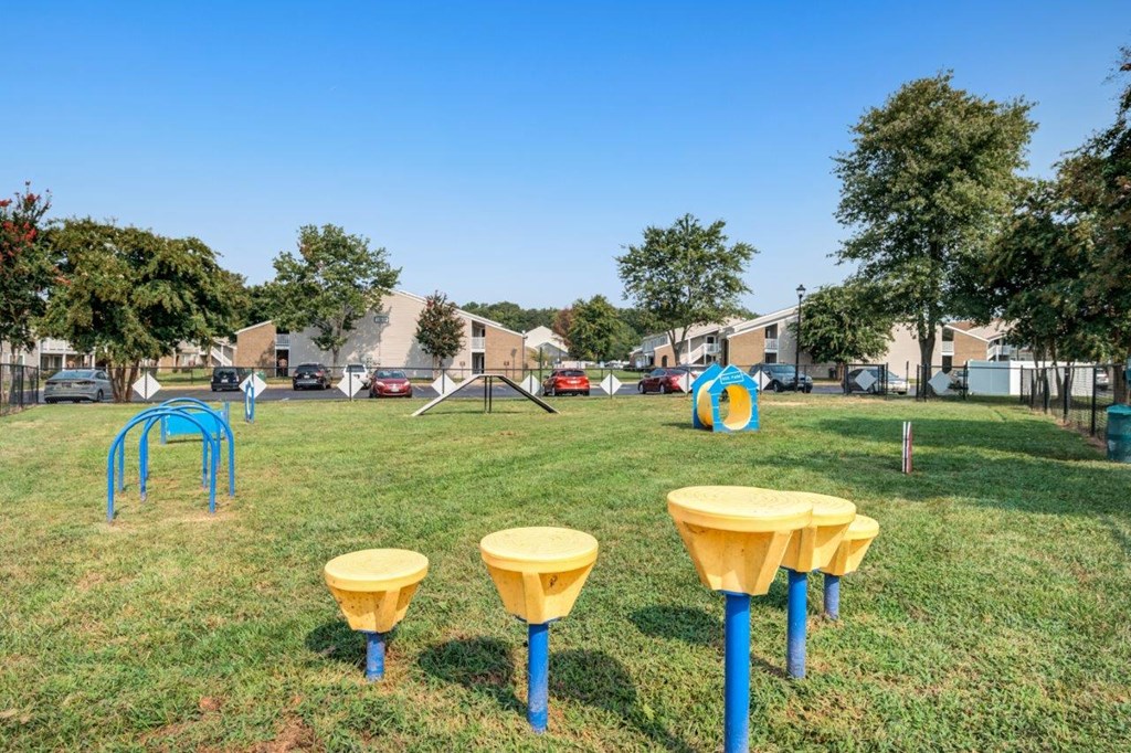 A playground with yellow and blue equipment and a blue sky in the background.