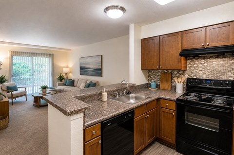 A kitchen with a black stove top oven and a sink with a faucet.