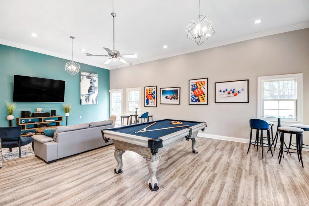 A room with a pool table and a television.