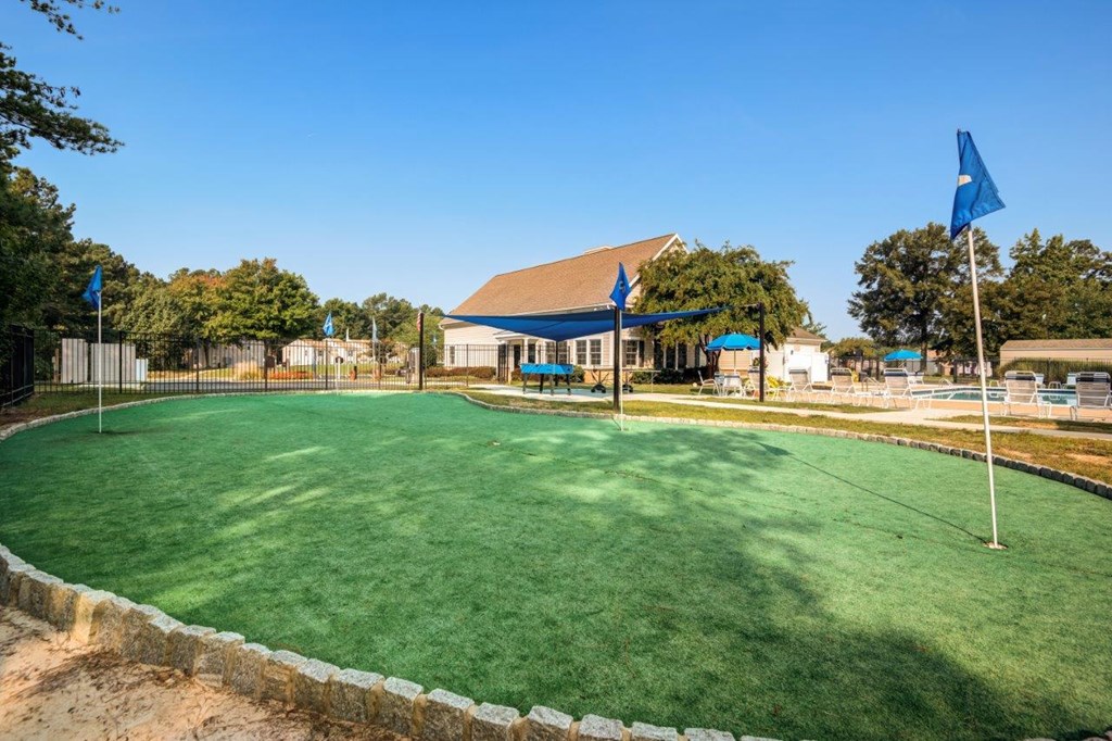A green lawn with a building in the background.
