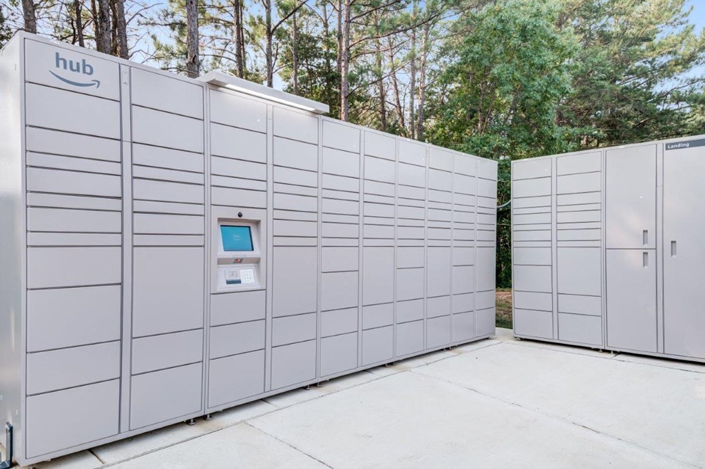 A row of white Amazon hub storage units are lined up in a row.