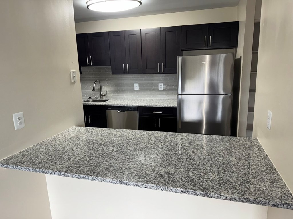 A kitchen with granite countertops and stainless steel appliances.