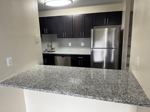 A kitchen with granite countertops and stainless steel appliances.