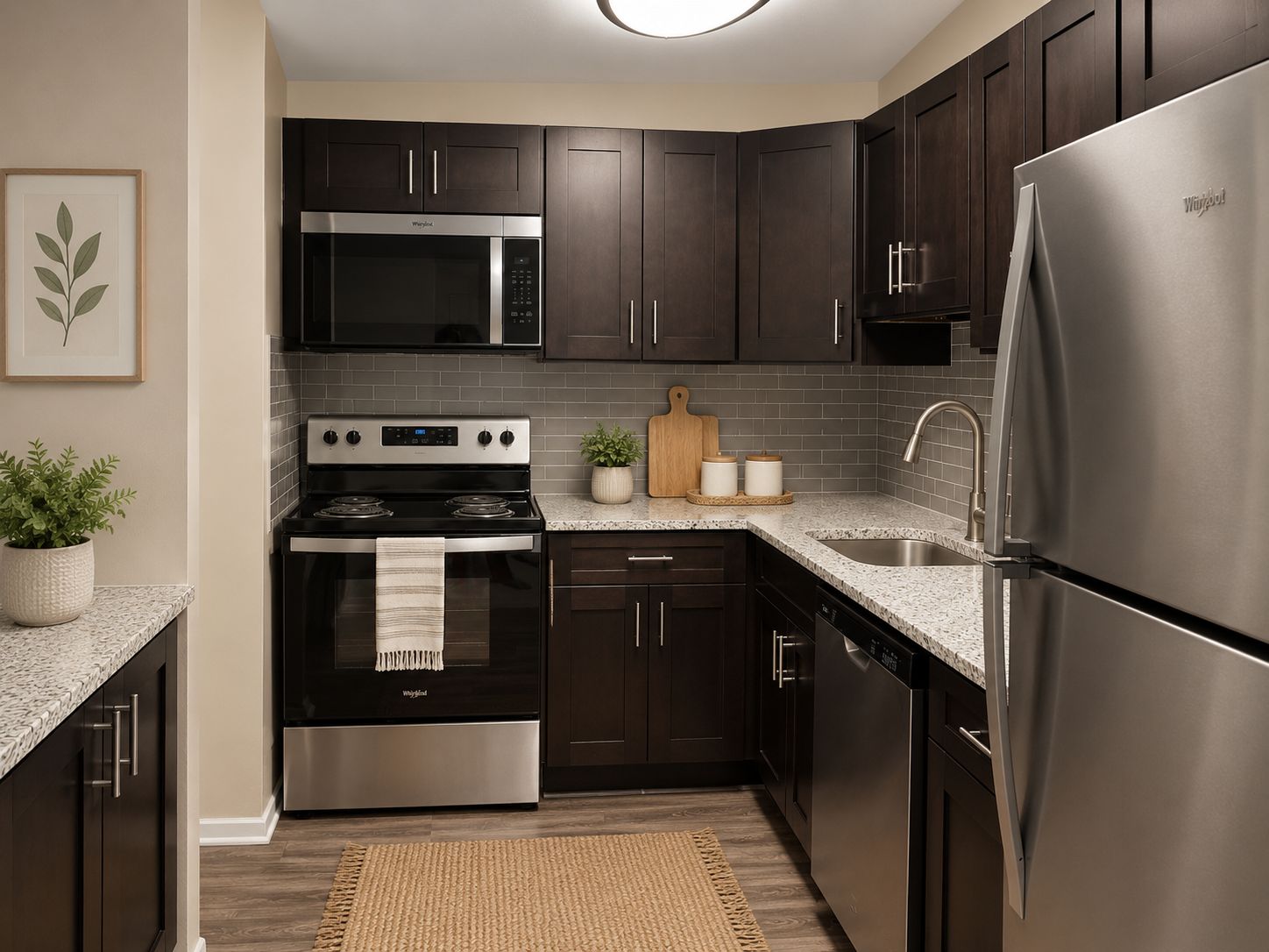 A modern kitchen with dark wood cabinets and stainless steel appliances.