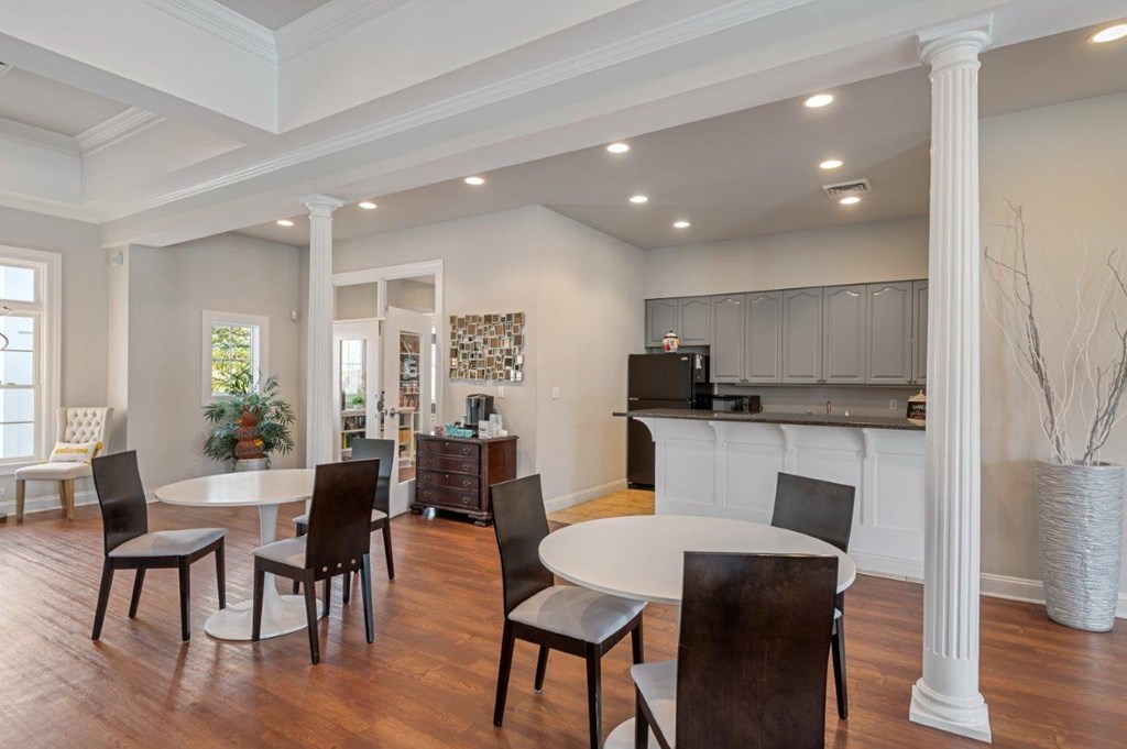 A dining room with a white table and chairs.