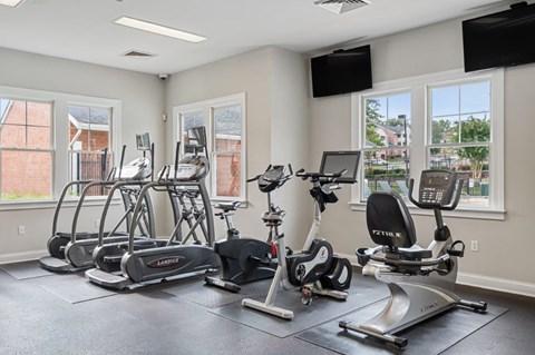 A spacious gym with treadmills, elliptical machines, and exercise bikes.