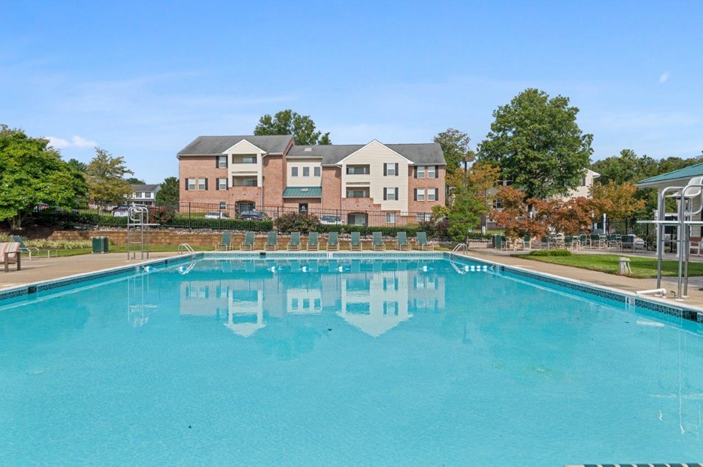 A large swimming pool in front of a multi-story building.