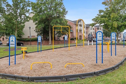 A playground with a yellow and blue play structure and a sandbox.