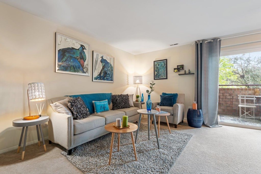 A living room with a grey couch, a coffee table, and a couple of side tables.