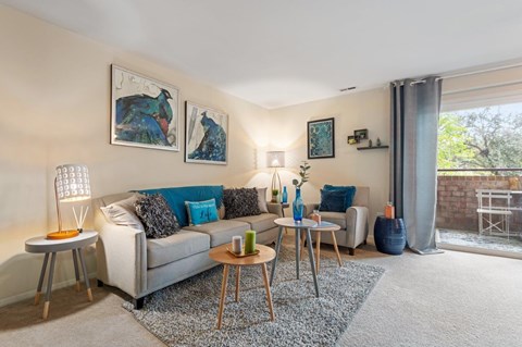 A living room with a grey couch, a coffee table, and a couple of side tables.