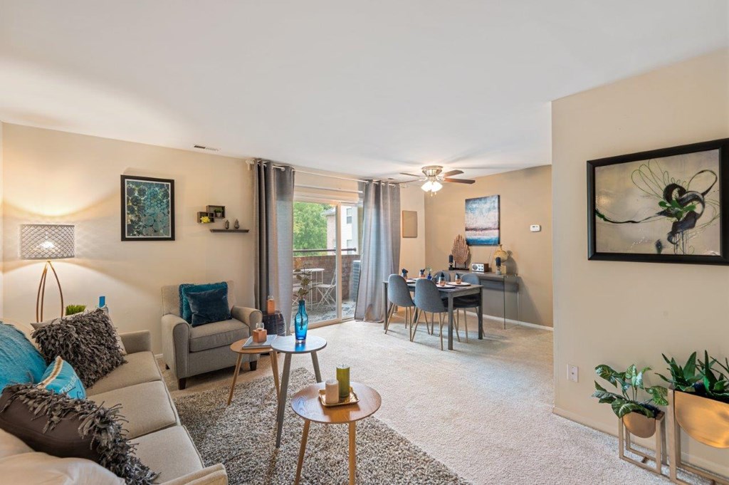 A living room with a grey couch, a coffee table, and a painting on the wall.