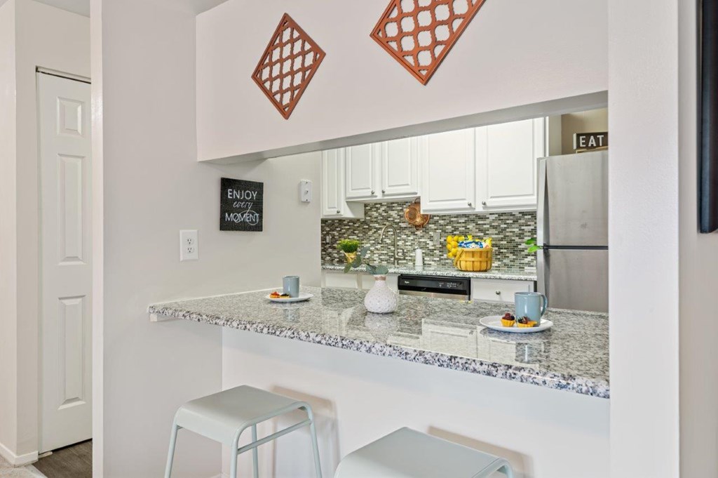 A kitchen with a granite countertop and a sign that says "ENJOY".