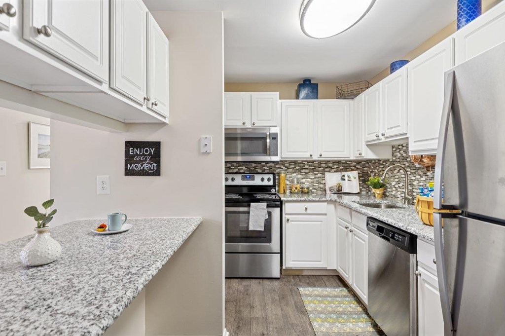 A kitchen with a granite countertop and stainless steel appliances.