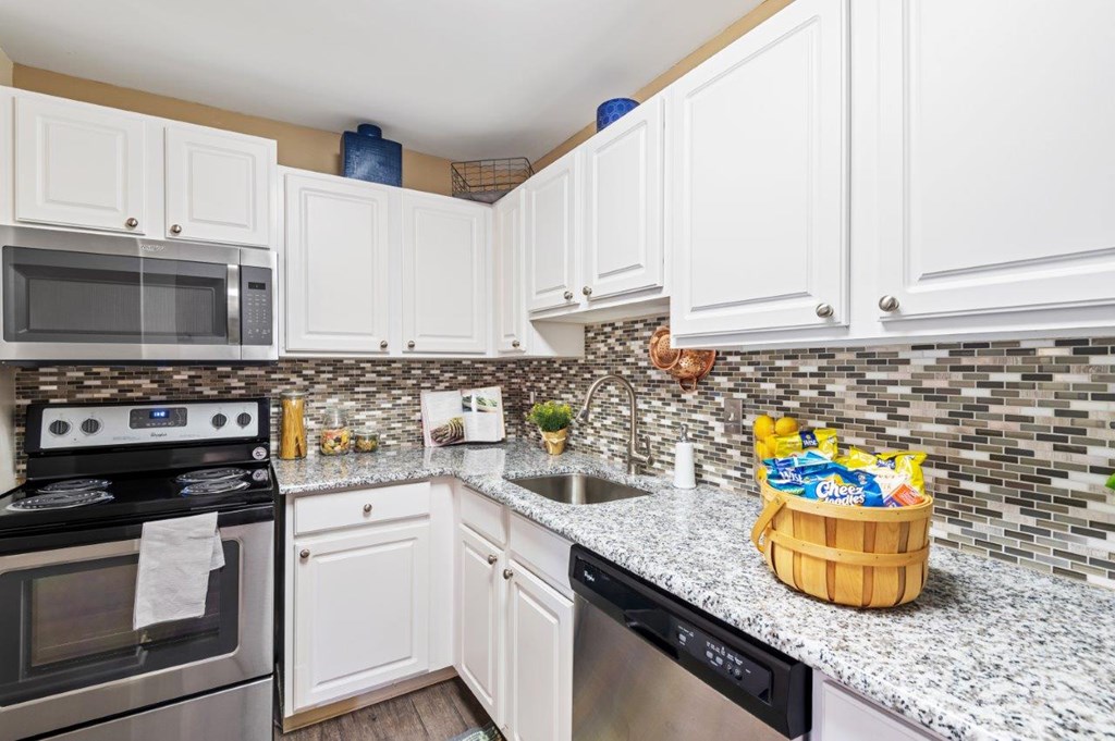 A kitchen with white cabinets and a black stove top oven.