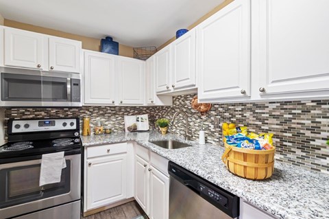 A kitchen with white cabinets and a black stove top oven.