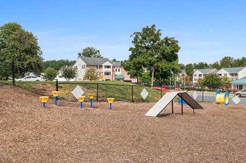 A playground with a slide and a few cones.