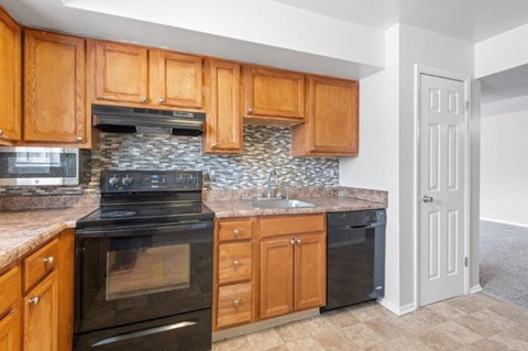 a kitchen with black appliances and wooden cabinets
