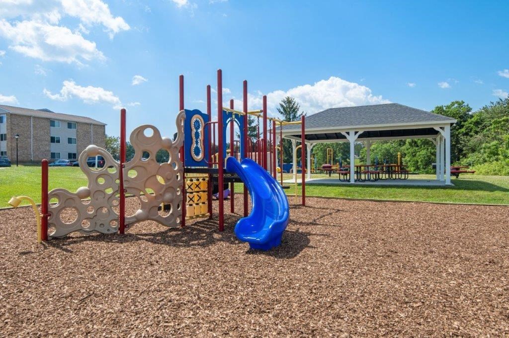 a playground with a blue slide at a park