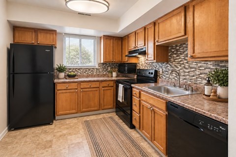 A kitchen with wooden cabinets and black appliances.