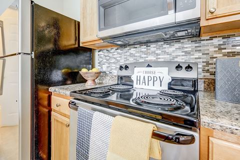 a kitchen with a stove and a microwave and a sign that says happy