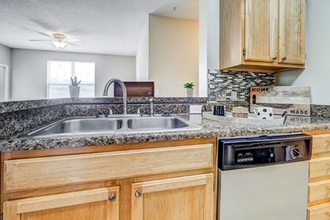 the kitchen has granite counter tops and wooden cabinets