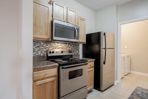 a kitchen with stainless steel appliances and wood cabinets