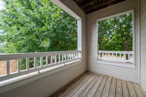 a covered porch with a view of trees
