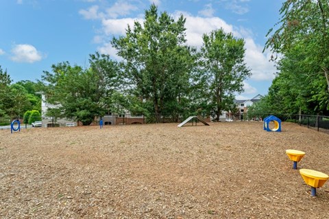 a playground with benches and trees in a park