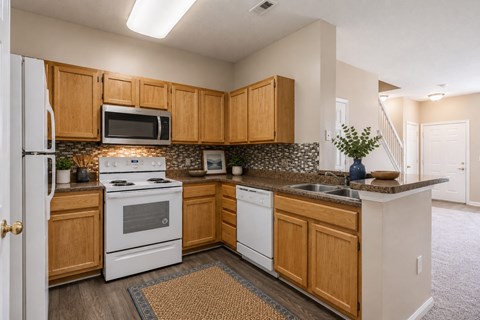 A kitchen with wooden cabinets and a white stove top oven.