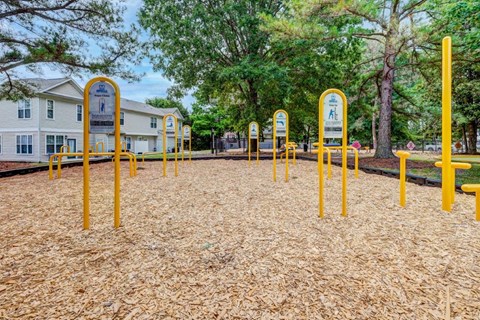 A playground with yellow poles and a sign in the middle.
