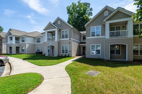 A row of houses with a car parked on the driveway.
