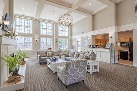 A living room with a grey carpet and a white sofa.