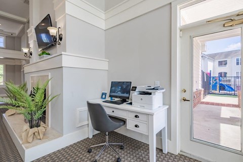 A white desk with a laptop and printer on it.