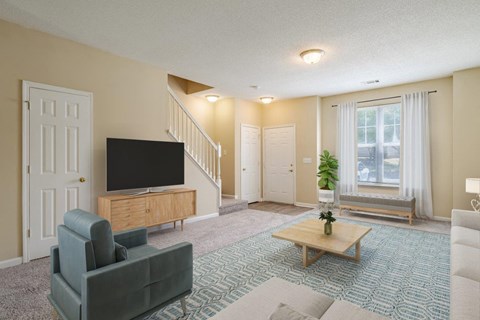 A living room with a grey couch, a wooden coffee table, and a television.