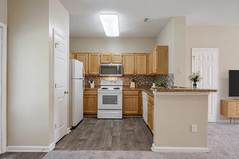 A kitchen with wooden cabinets and a white stove top oven.