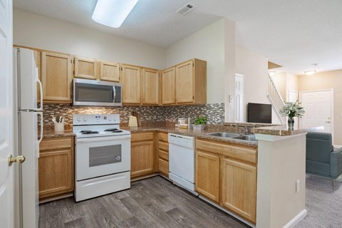 A kitchen with a white stove and white oven.