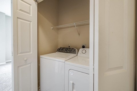 A white washing machine and dryer in a small laundry room.