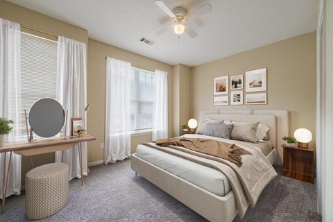 A bedroom with a large bed, a vanity table, and a window with curtains.