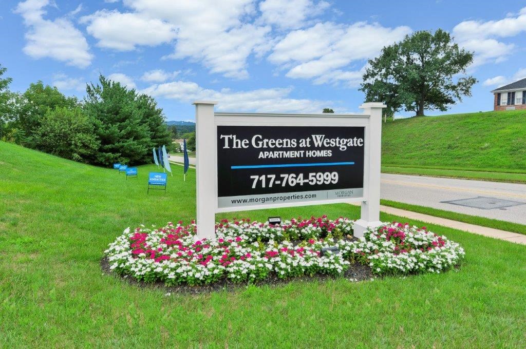 the greens at wesleyan sign in front of flowers