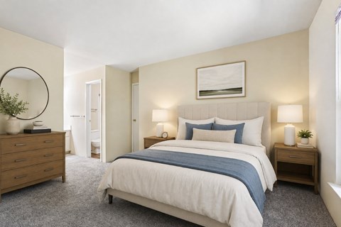 A bedroom with a large bed, a dresser, and a nightstand with lamps.