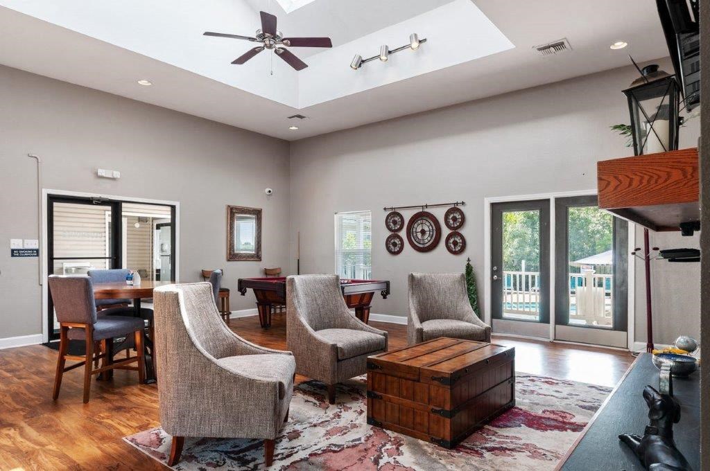 a living room with a table and chairs and a ceiling fan