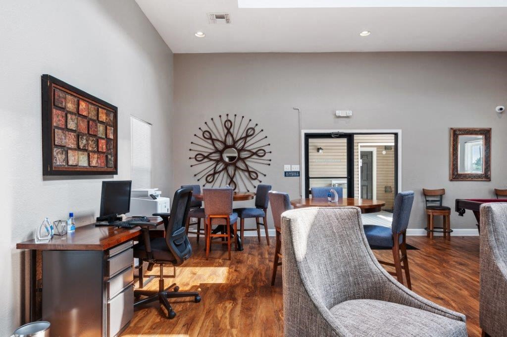 a living room and dining room with a desk and chairs