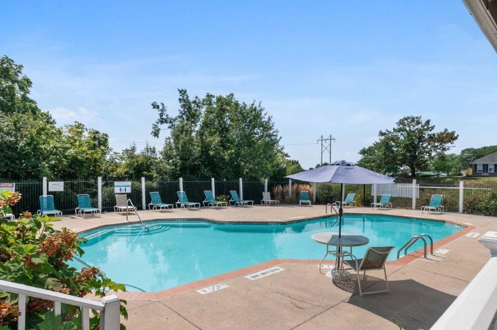 a swimming pool with chairs and an umbrella