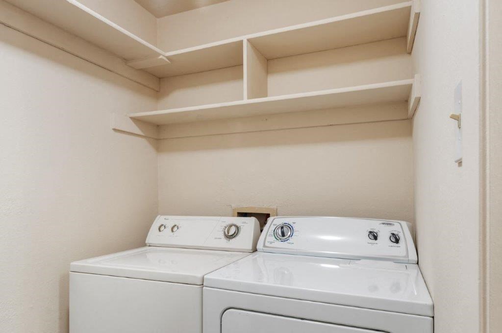 an empty laundry room with two washes and a dryer